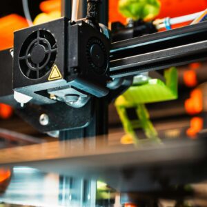 Detailed view of a 3D printer nozzle working in a modern manufacturing setting.